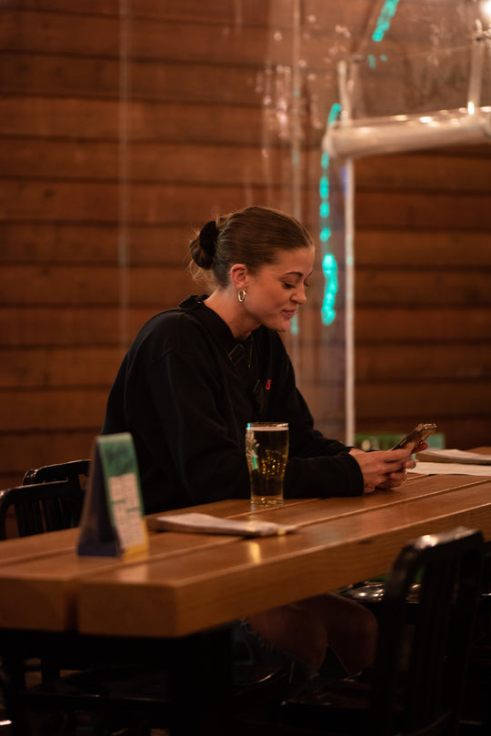 Tapworks Brewing in Gibsons, a woman enjoys craft beer in a cozy setting, capturing the relaxed vibe of brewpub patio.